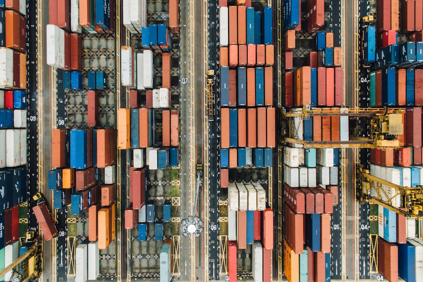 Aerial view of a real container terminal with cargo containers, vessels and cranes.