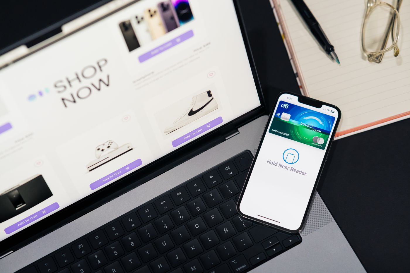 A laptop displaying ecommerce alongside a mobile payment phone.
