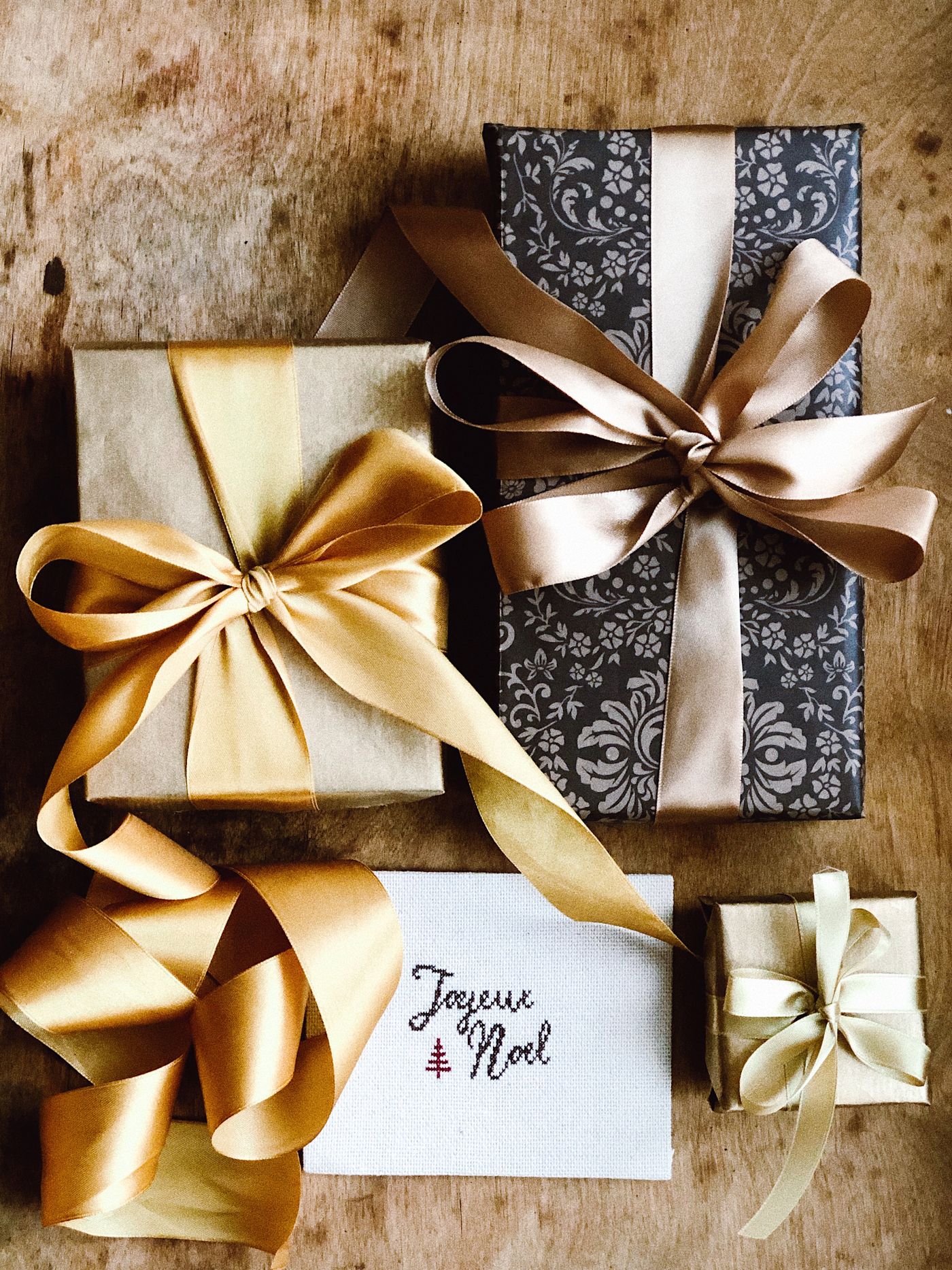 Christmas gifts wrapped with ribbons on a wooden surface