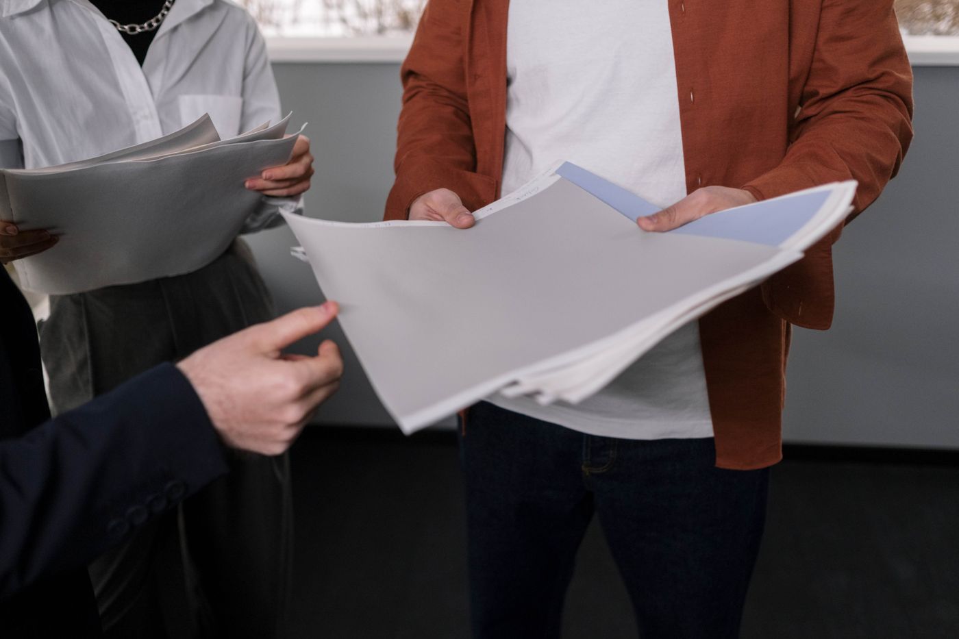 Business professionals review physical design and color samples at a table.