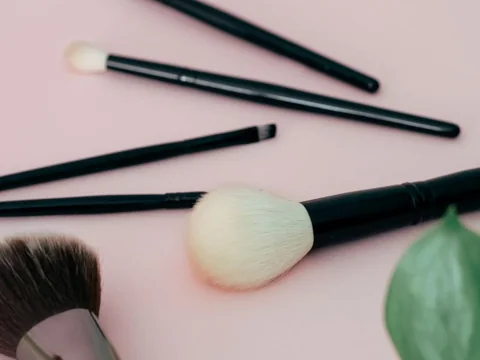Makeup brushes on a pale pink background