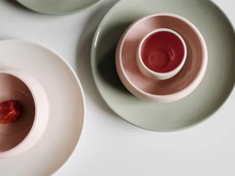 Ceramic bowls and plates arranged on a white table