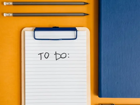 Notebooks and writing supplies on an orange background