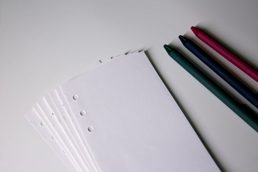 A set of colored pens and white paper