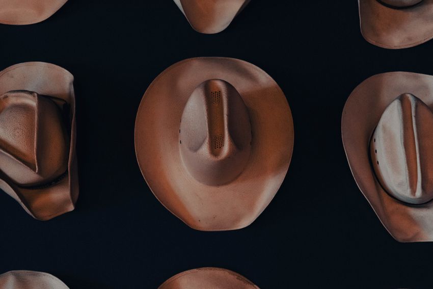 Brown hats arranged on a dark background