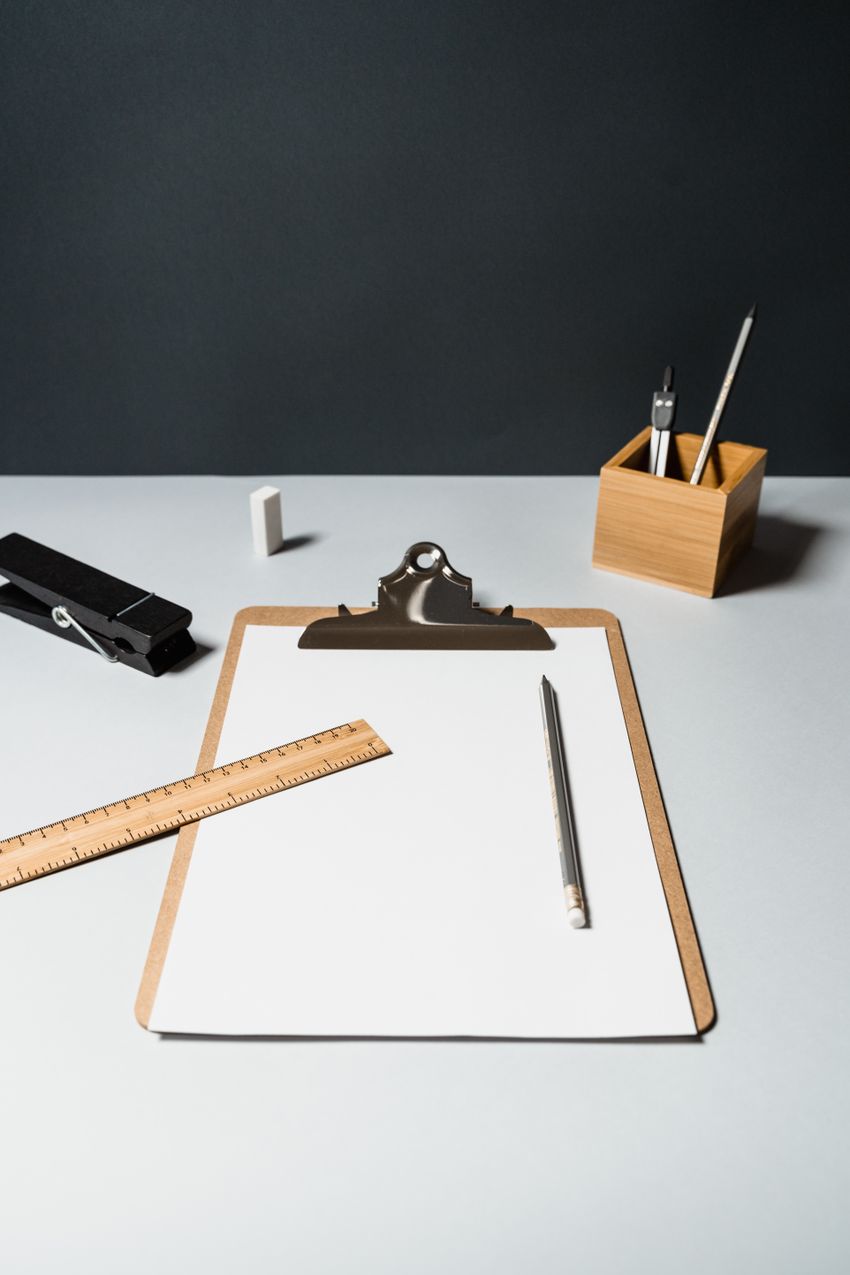 Office supplies arranged around a clipboard