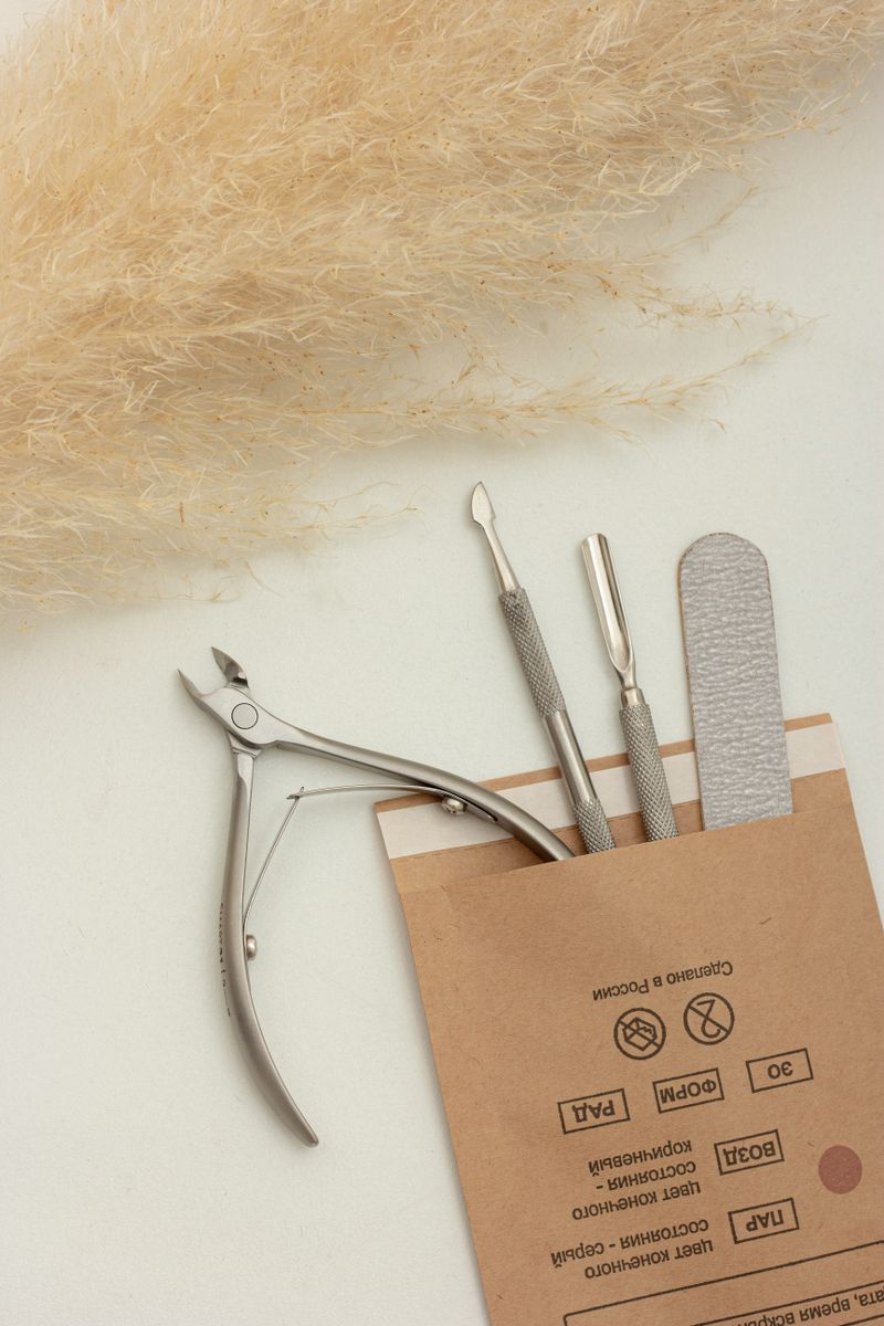 Manicure tools arranged beside dried grass