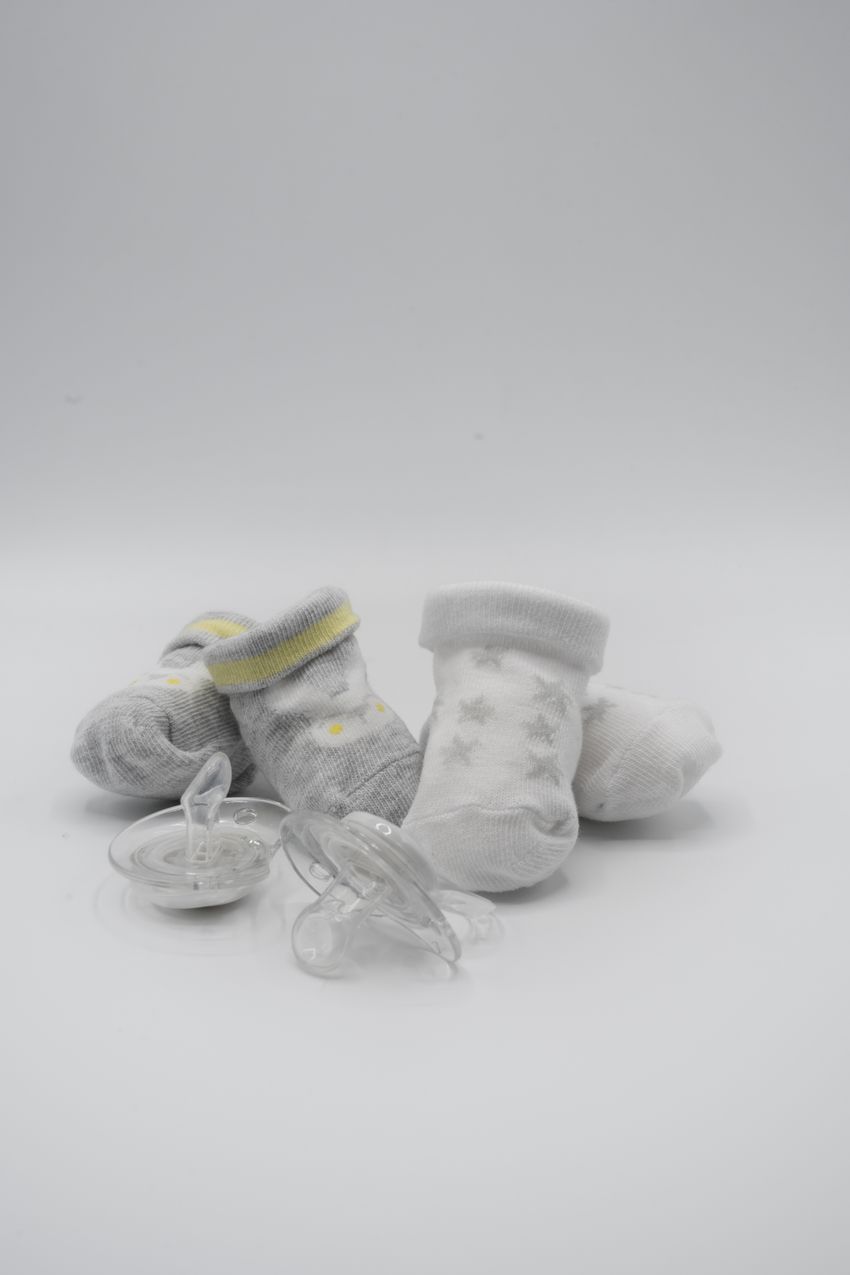 Baby pacifiers and socks on a clean white background