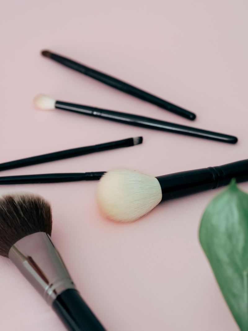 Makeup brushes on a pale pink background