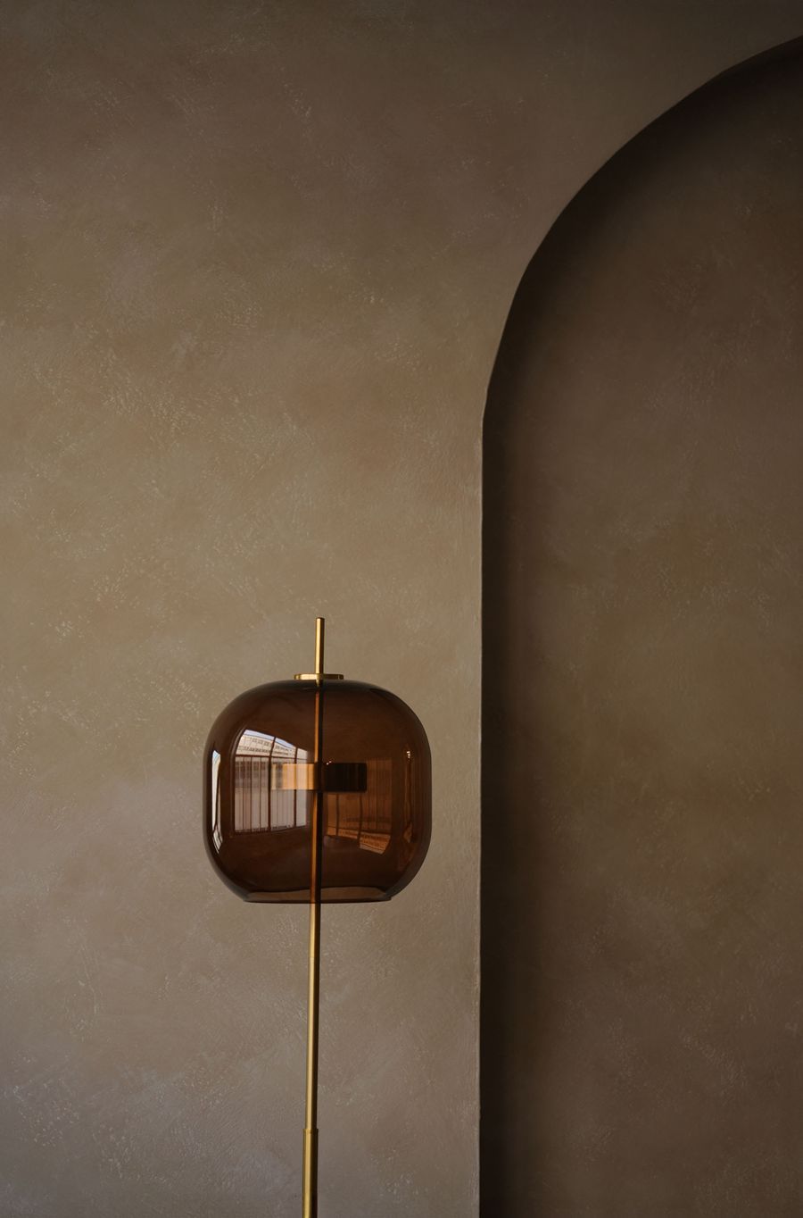 A contemporary floor lamp against a warm neutral wall