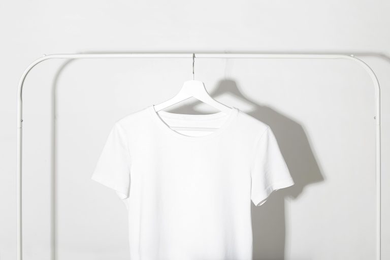 A plain white T-shirt hanging on a rail