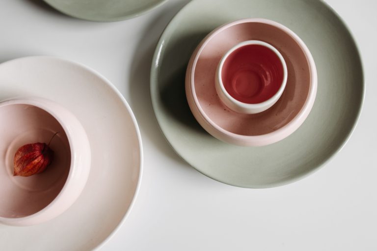 Ceramic bowls and plates arranged on a white table