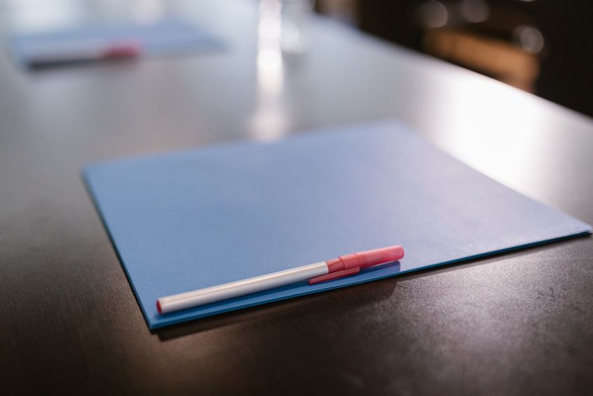 A blue document folder and pen on a table