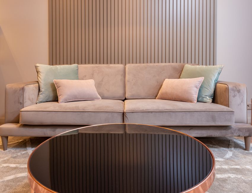 A beige upholstered sofa with cushions in a living room